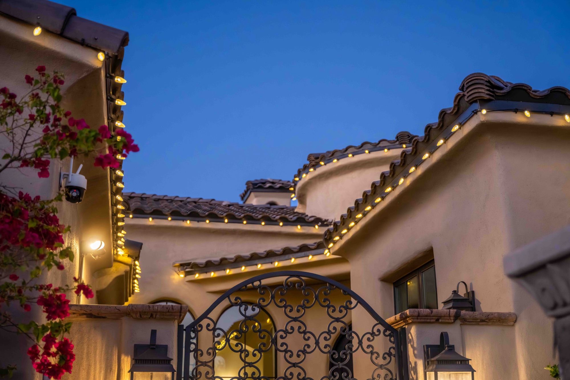 Roofline lighting and bougainvillea at a Paradise Valley entry gate
